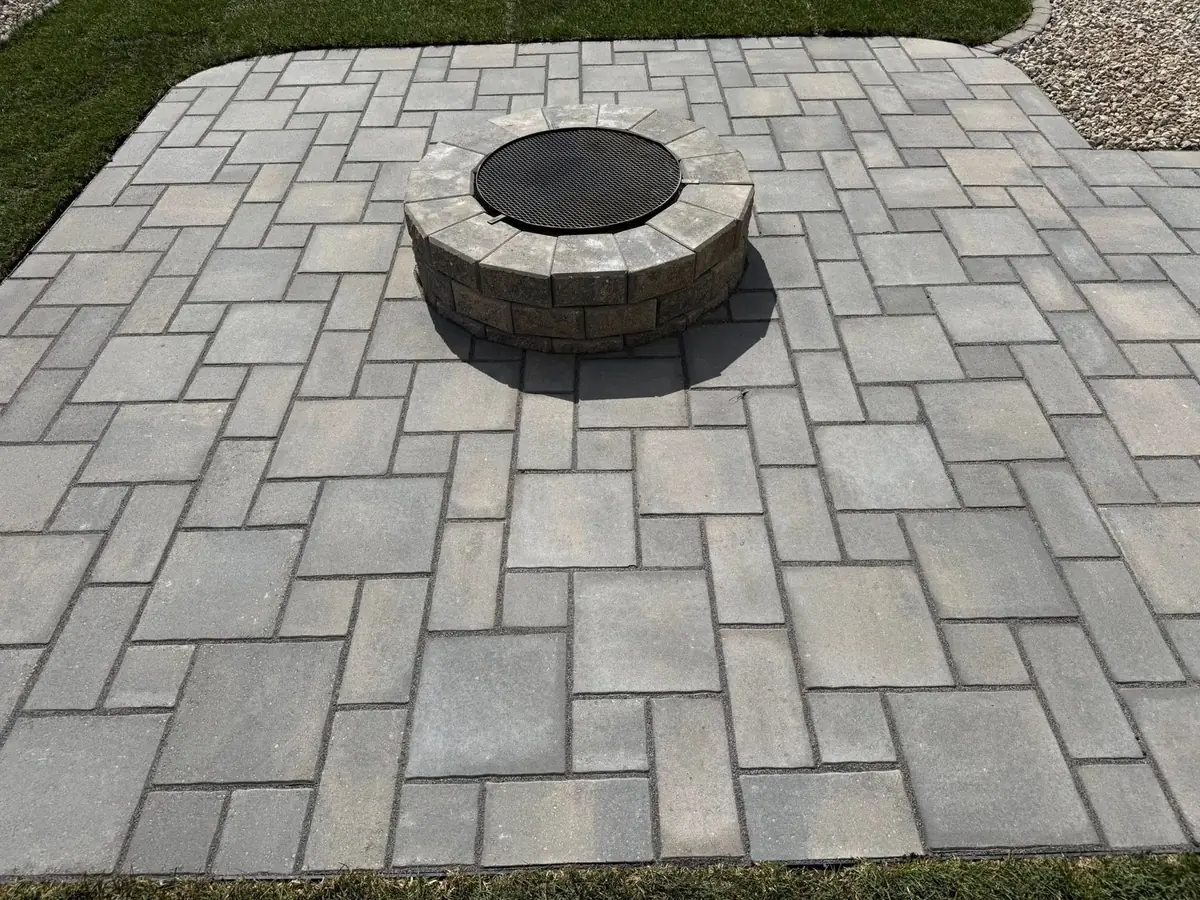 A paver patio with a built-in fire pit, installed by Heads Up